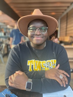 a student smiling wearing a hat