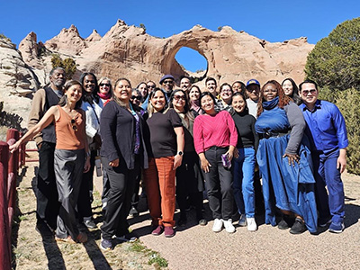 A group poses in front on an arch