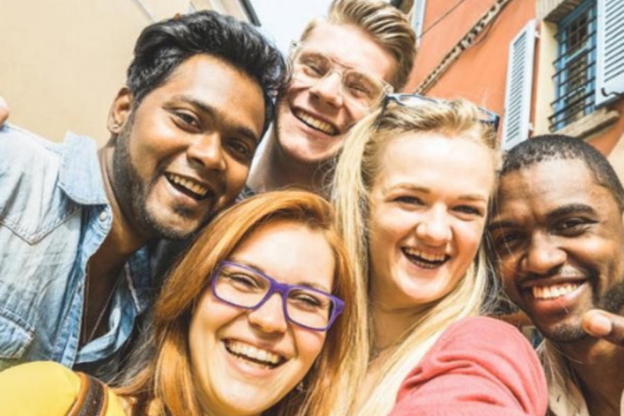 A group of students pose for a selfie outside