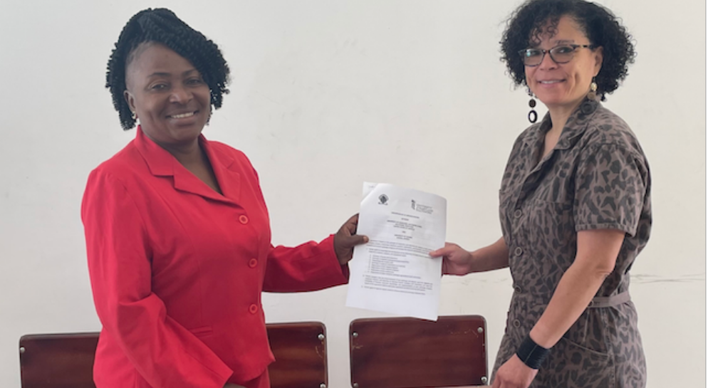 Two women hold a document between them