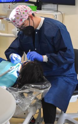 Benjamin Hung, a third-year dental student, provides oral health care to a young patient at Sealant Saturday.