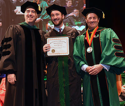 From left, Associate Dean Joseph Martinez, graduate Zachary Brilliant, and Dean Mark Gladwin