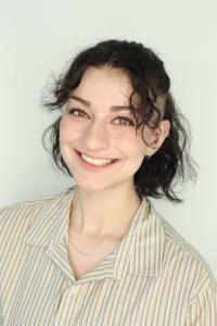 Headshot of Kayla Kozak from the shoulders up smiling, wearing collared shirt