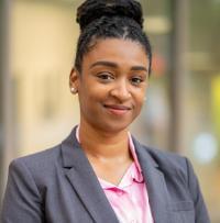 Headshot of Tanika Wiggins from the shoulders up smiling wearing a blouse and blazer