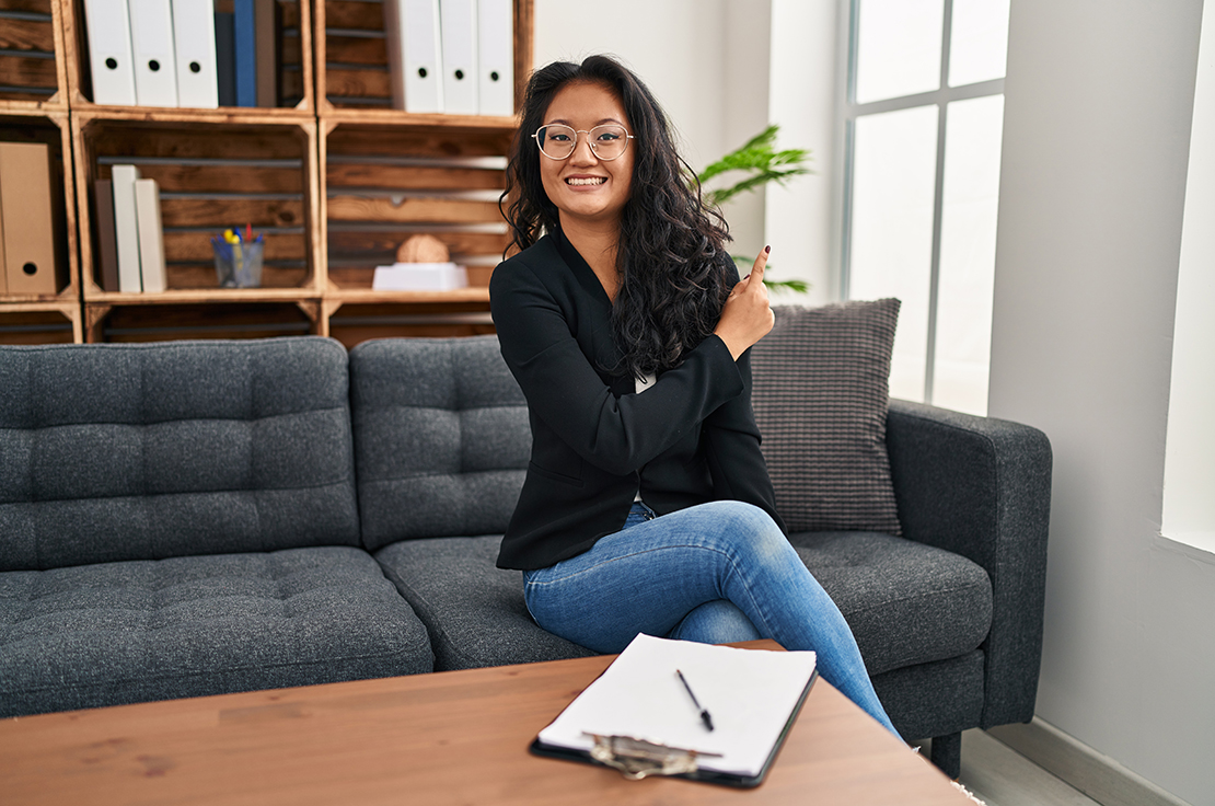 Woman sitting on couch with notebook