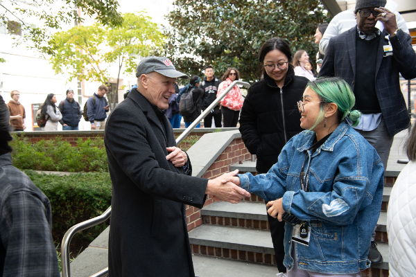 President Jarrell shaking hands with a student